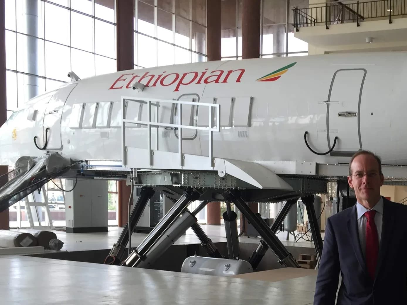 Geoffrey Kirkman in an Ethiopian Airlines training hangar in Addis Ababa, an aircraft fuselage behind him